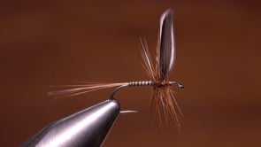A fly vise holding a undefined after it is tied