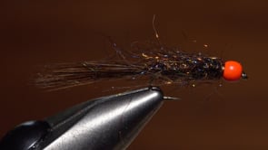 A fly vise holding a undefined after it is tied