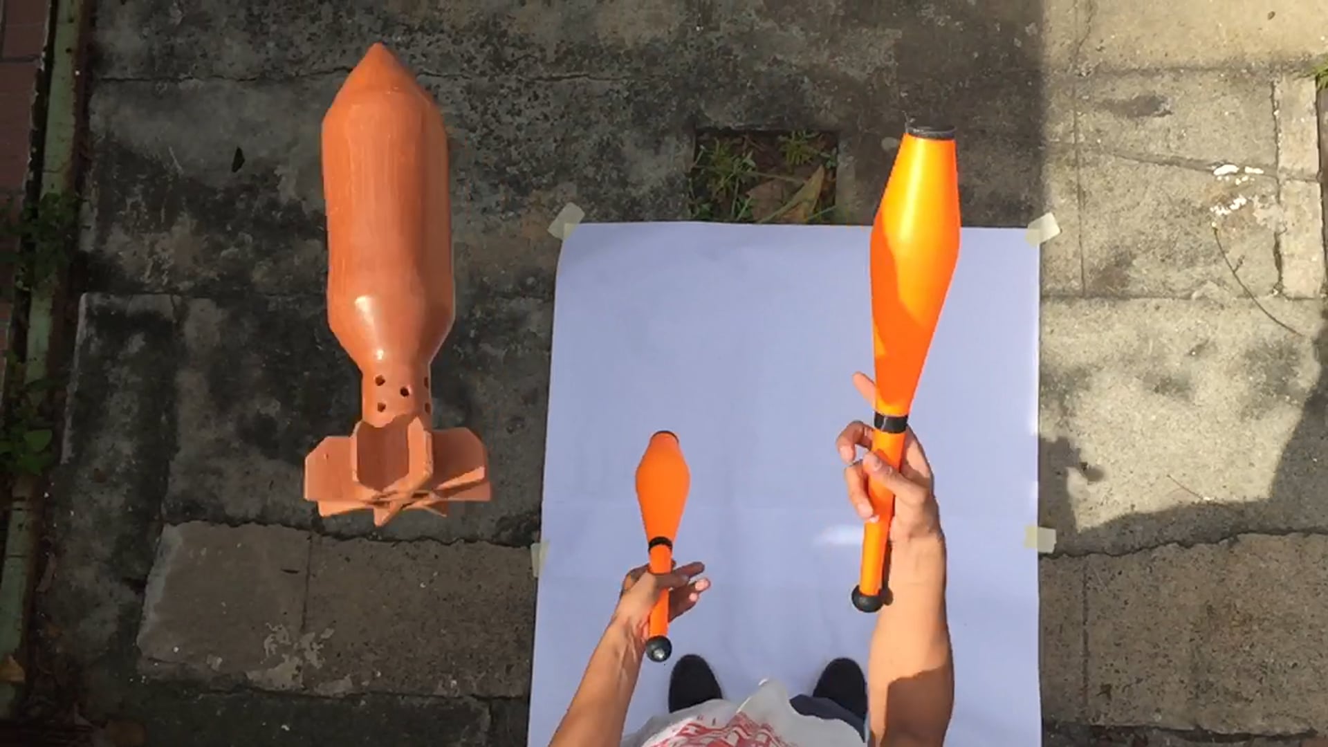 Malabares con dos clavas y una bomba