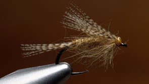 A fly vise holding a undefined after it is tied