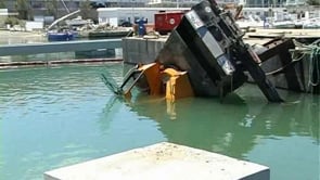 Una grua cau a l'aigua al port de l'Escala