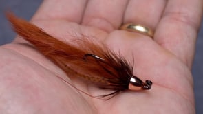 A fly vise holding a undefined after it is tied