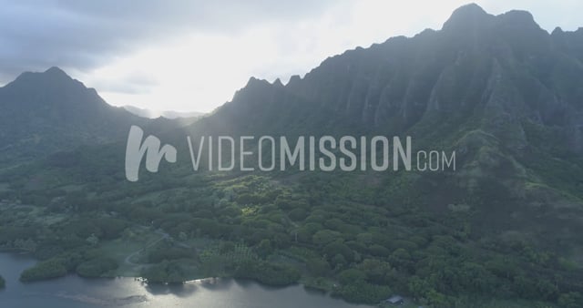 Drone Flying Over Forest Toward Mountain Light Rays