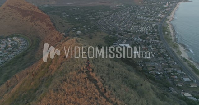 Drone View Of Man On Ridge Revaling Bay