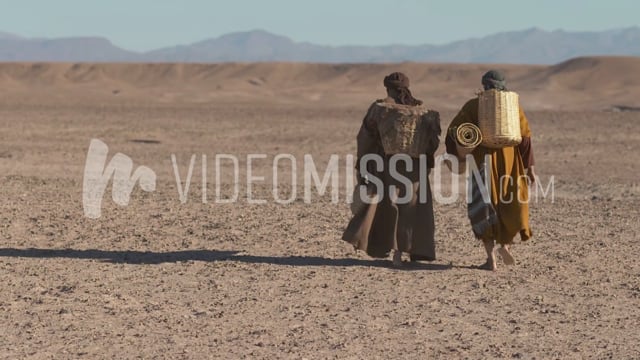 Back Shot Of Men Walking Into The Desert