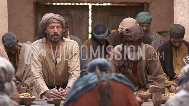 Man Praying With Group Around A Table