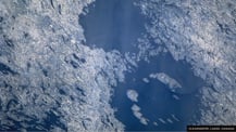 Satellite image of two lakes filling impact craters. Text in the bottom right corner reads "Clearwater Lakes, Canada."