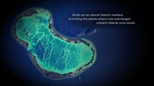 Satellite image of an atoll. Text toward the upper right reads "Atolls act as natural historic markers, encircling the places where now-submerged volcanic islands once stood."