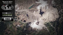 Satellite image of Mount Saint Helens as seen in 1984. The image is overlaid in the top left corner with title text that reads "Mount Saint Helens, Washington State." Just below is a map of the world with a small red dot marking the location of the volcano. Further below is the "World of Change" logo and a gray box with the year "1984" in it.