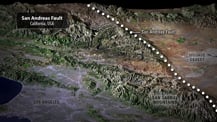 Satellite image of a portion of California with labeled features. A gray box in the top left corner has text that reads "San Andreas Fault, California, USA." Toward the upper right are small white dots, which trace the path of the San Andreas Fault.