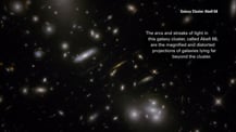 Image of Galaxy Cluster Abell 68. Text in the top right corner reads "Galaxy Cluster Abell 68." Text toward the upper right reads "The arcs and streaks of light in this galaxy cluster, called Abell 68, are the magnified and distorted projections of galaxies lying far beyond the cluster."