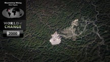 Satellite image of mountains as seen in 2000. The image is overlaid in the top left corner with title text that reads "Mountaintop Mining, West Virginia." Just below is a map of the world with a small red dot marking the location of the mountains. Further below is the "World of Change" logo and a gray box with the year "2000" in it.