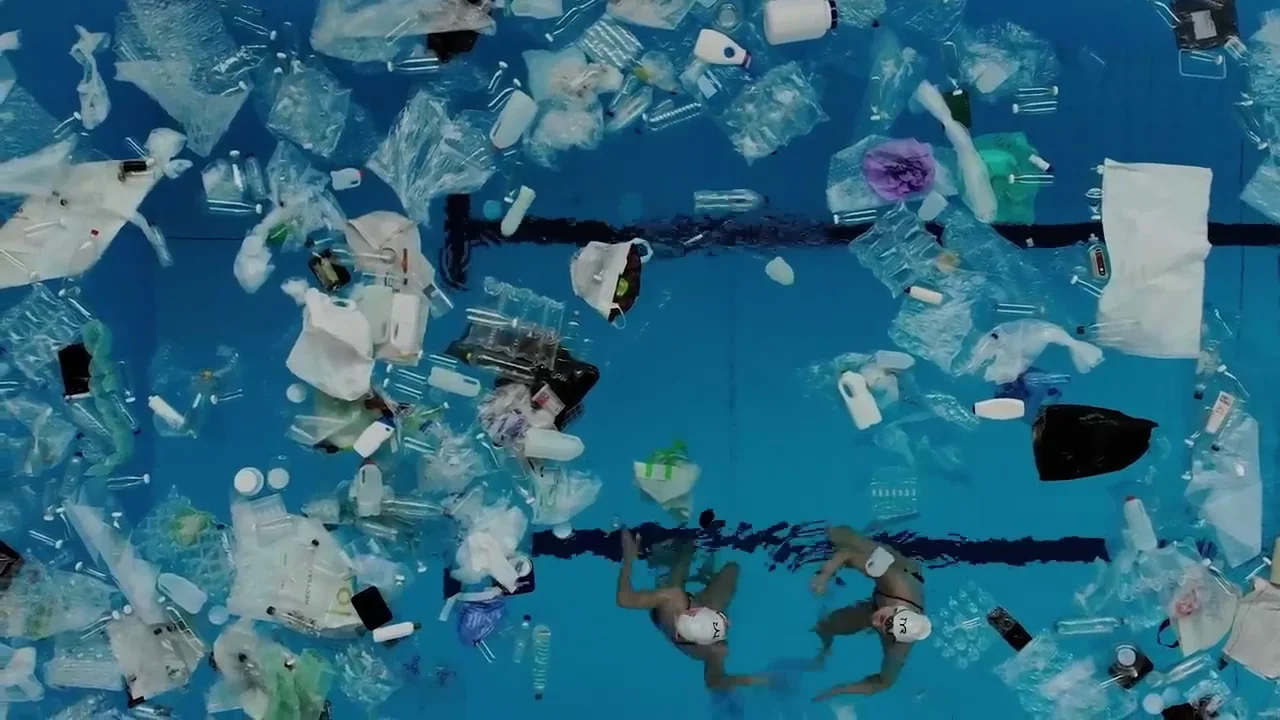 synchronized swimmers in a pool full of rubbish raise awareness of ...