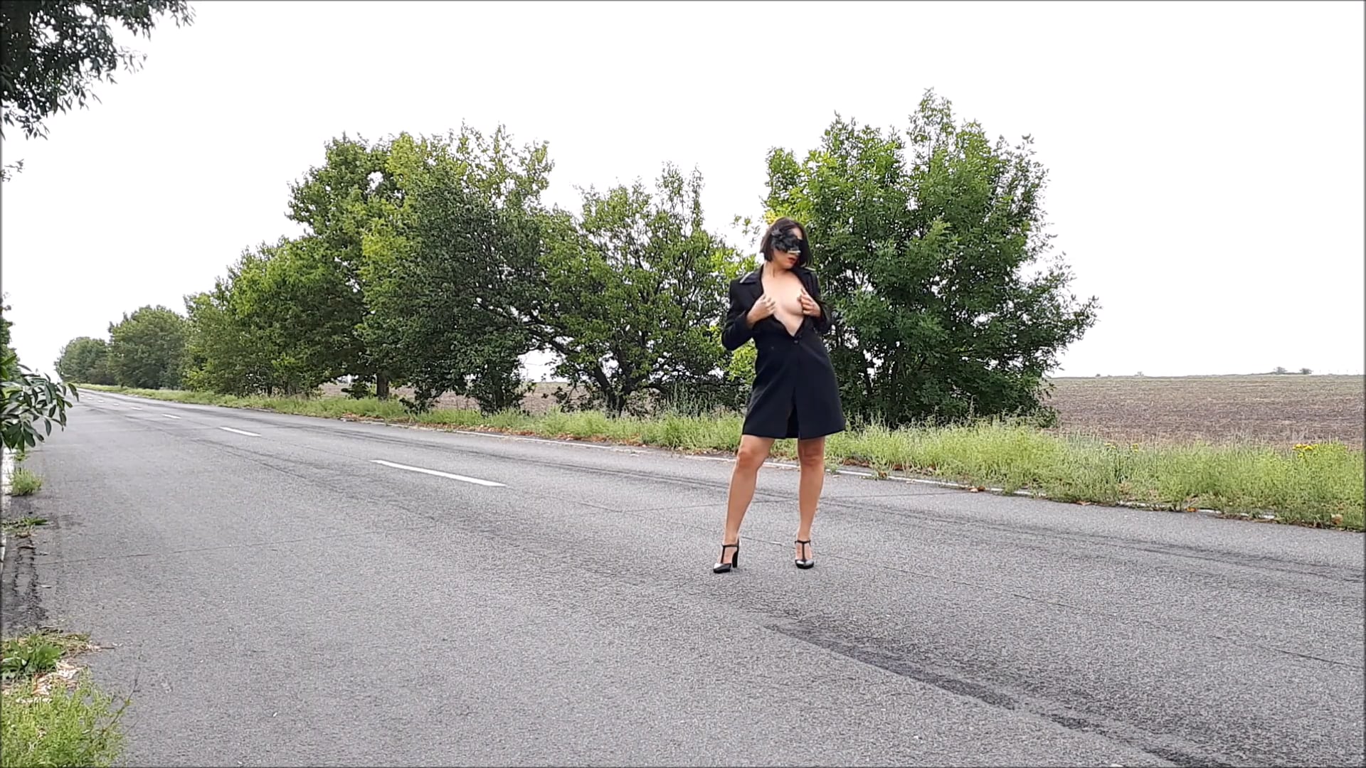 Provocation on the road nude in a black mask and cardigan