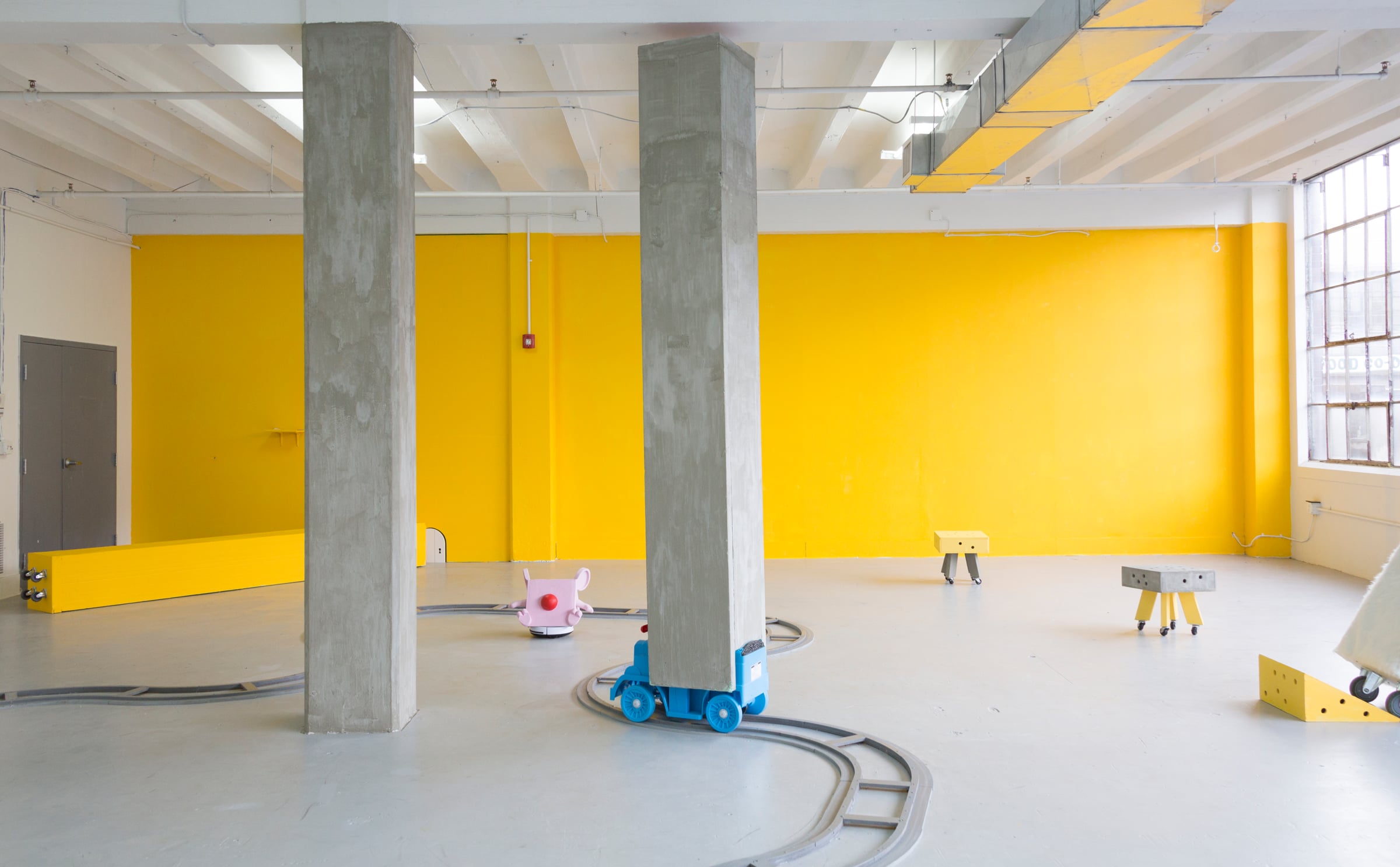 Installation view of Huidi Xiang’s Cheese Column, a site-specific kinetic installation incorporating a large architectural column and cartoon-inspired sculptural elements.